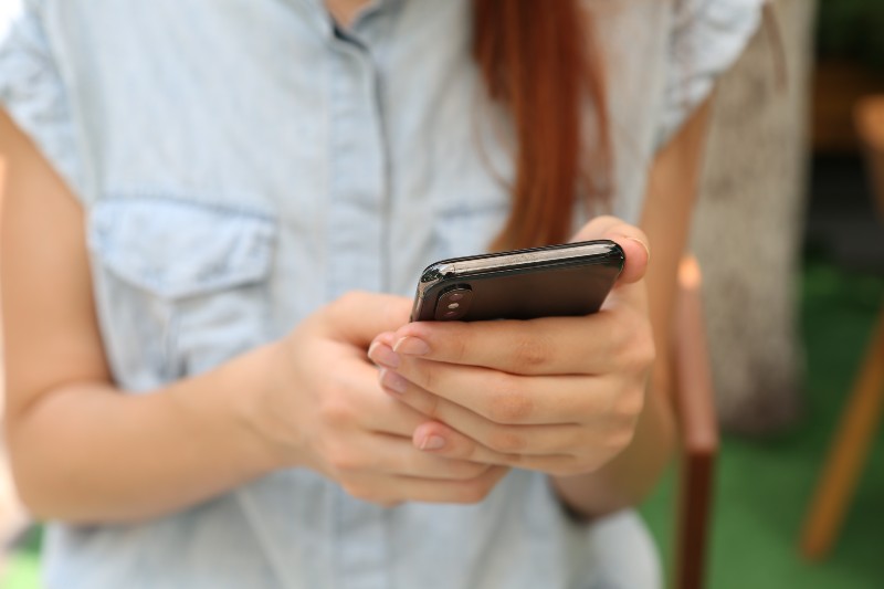 Wie Sie Ihre Musik im Radio spielen lassen - Person, die am Telefon simst