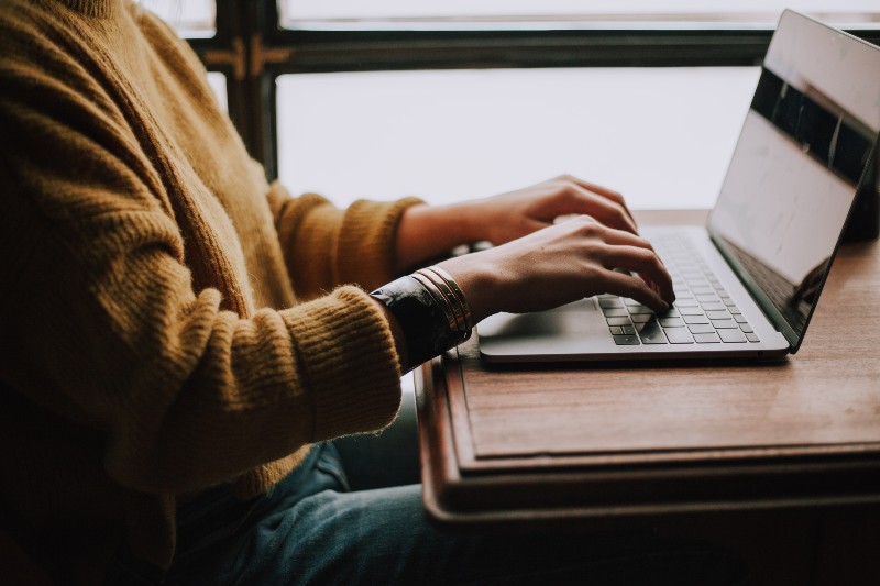 Wie Sie Ihre Musik im Radio spielen lassen - Person, die auf einem Laptop tippt